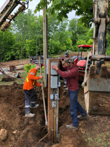 UPL Electrical team members installing a home electrical post