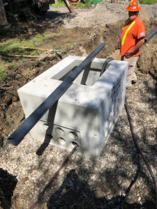 UPL Electrical team member standing in a trench beside an electrical utility vault