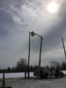 UPL Electrical team member fixing wiring on a pole line